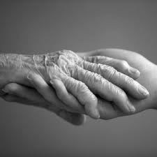 ruky mladej opatrovateľky hladia a upokojujú ruky starej osoby